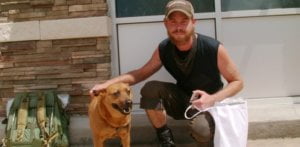 homeless guy with dog on the street living outside 1